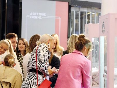 A group of women playing a claw machine