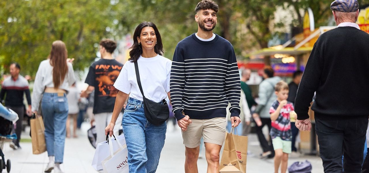 Couple walking hand in hand down the Mall with shopping bags