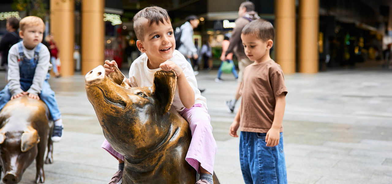 Kids playing on pigs sculptures