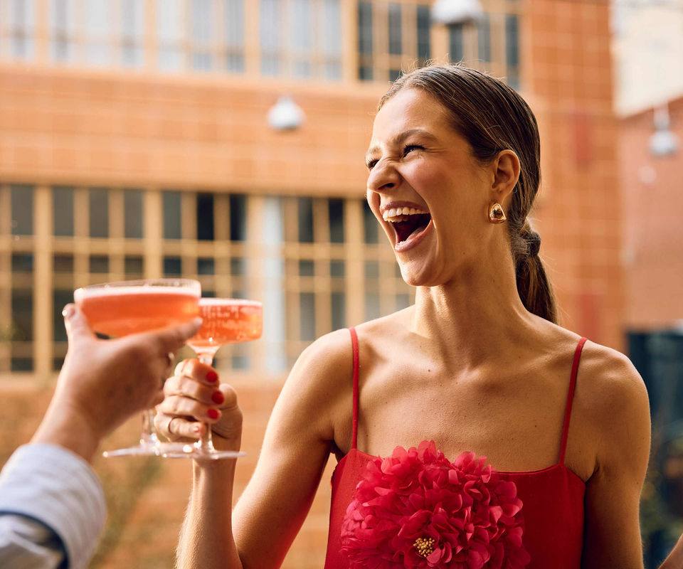 Happy girl in a red dress with a drink