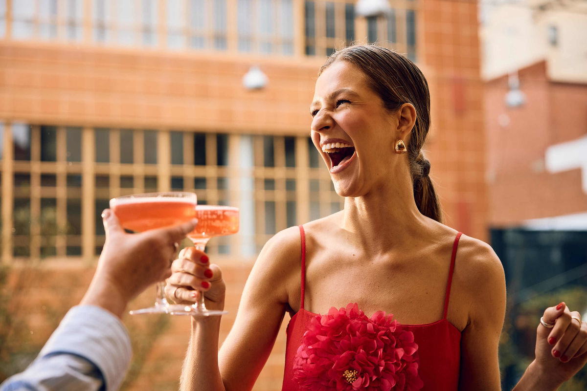 Happy girl in a red dress with a drink