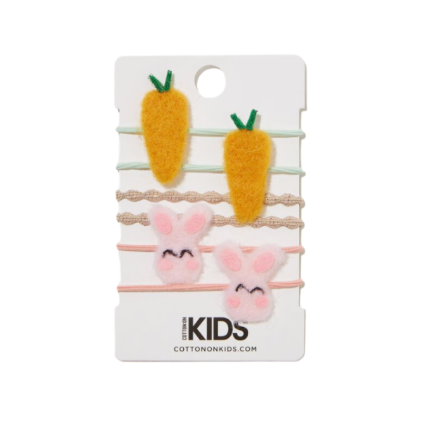 A group of hair ties on a cardboard backing. Some hair ties have carrots on them, some have bunnies