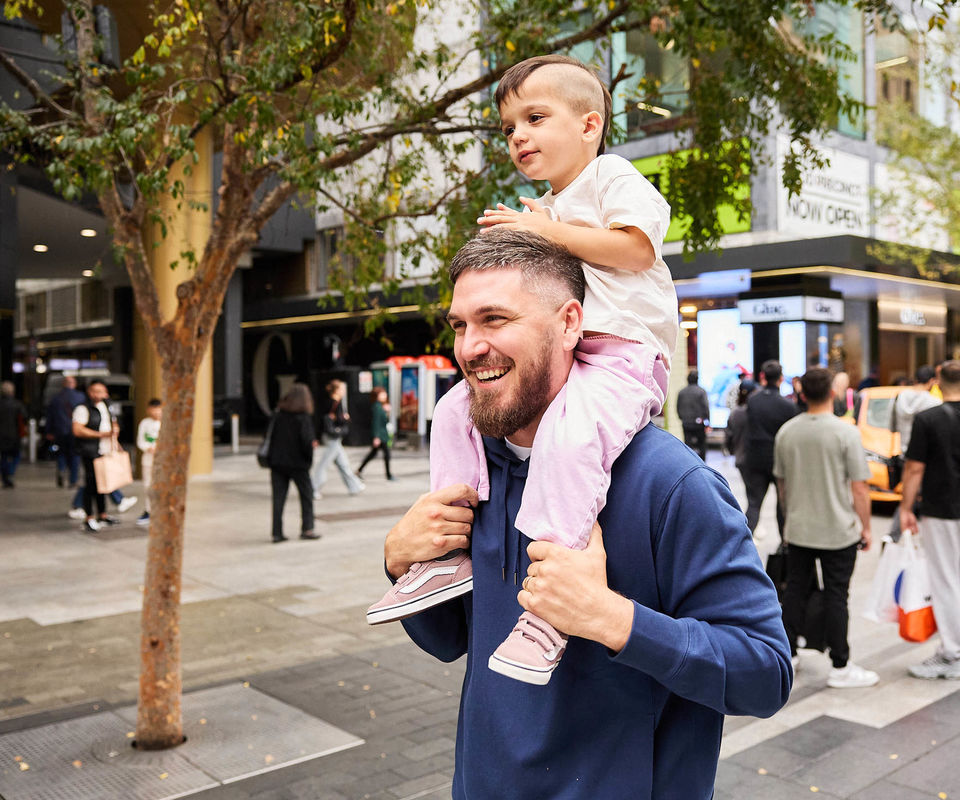Man laughing with his young son sitting on his shoulders
