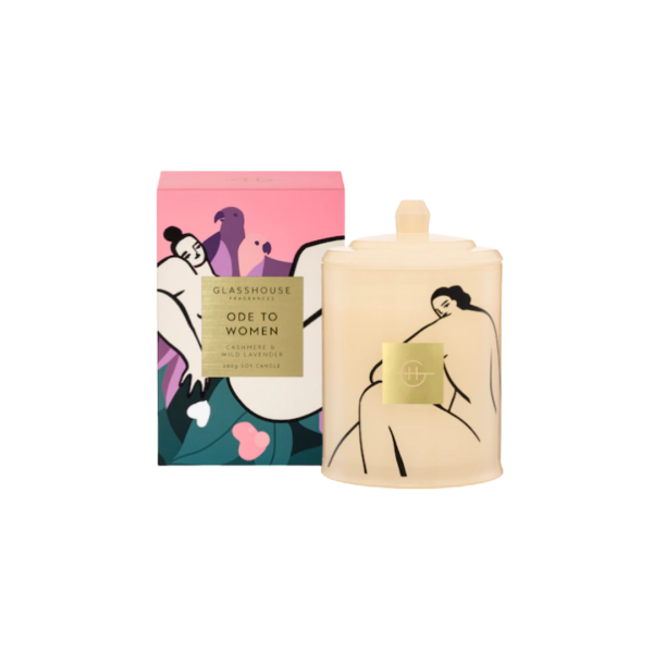 A pink, green and purple box with a cream coloured candle next to it