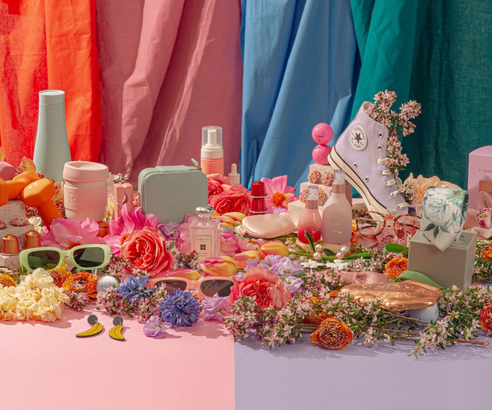 An array of products from Rundle Mall surrounded by flowers and on a bold backdrop