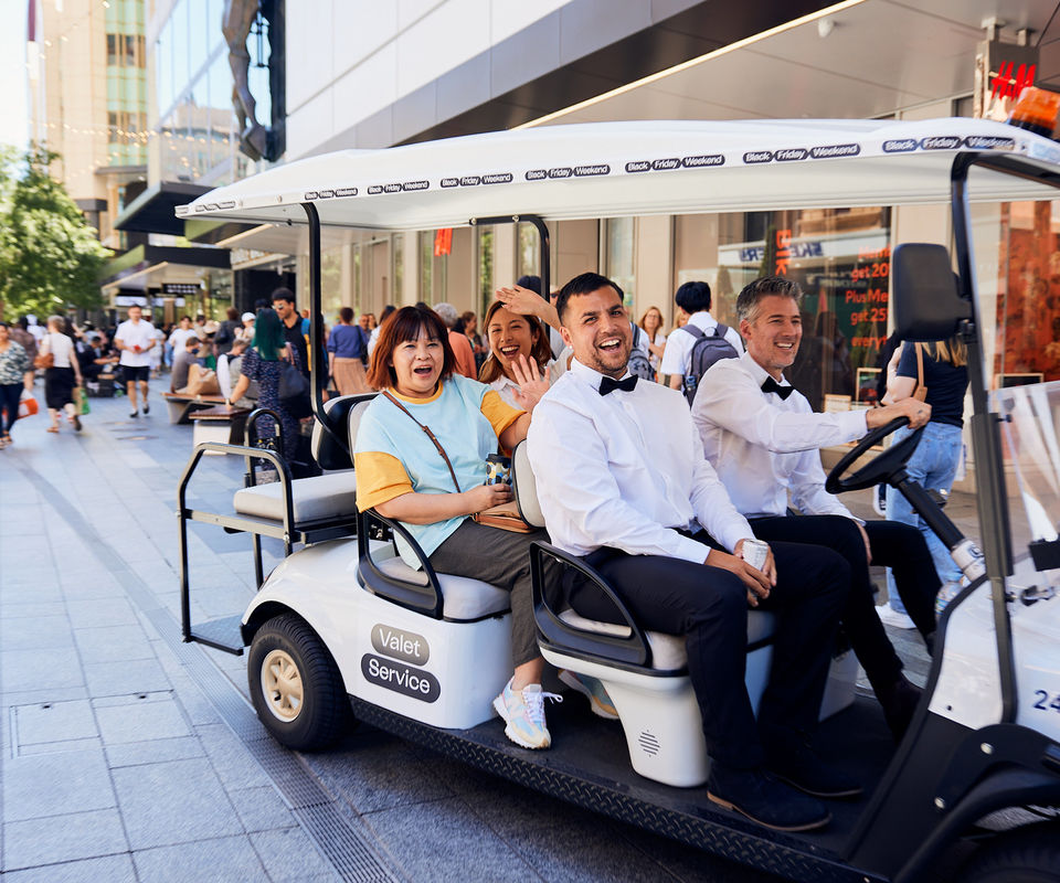 Two chauffeurs in black tie driving customers around in the Black Friday buggy