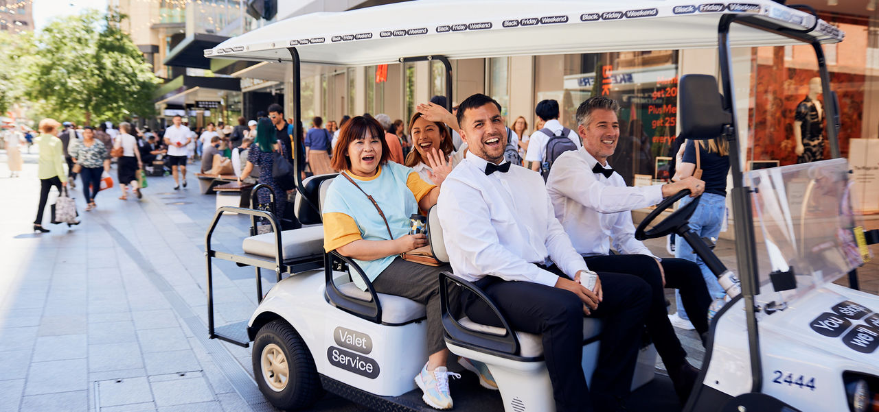 Two chauffeurs in black tie driving customers around in the Black Friday buggy