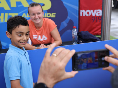 Child having a photo with one of the tennis players