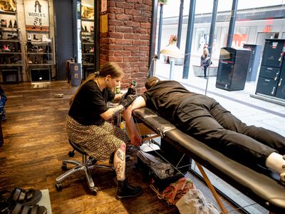 A man getting a tattoo on his arm