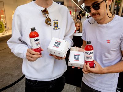 Two men holding food and drinks