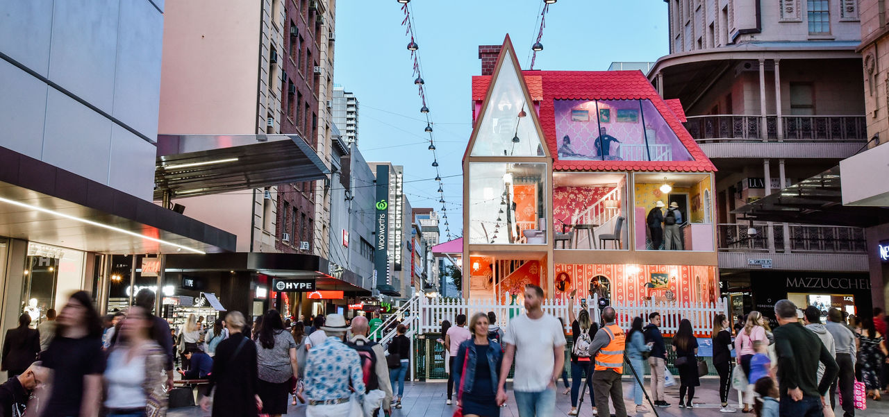 People in the Mall at dusk with the Doll's House display in the background