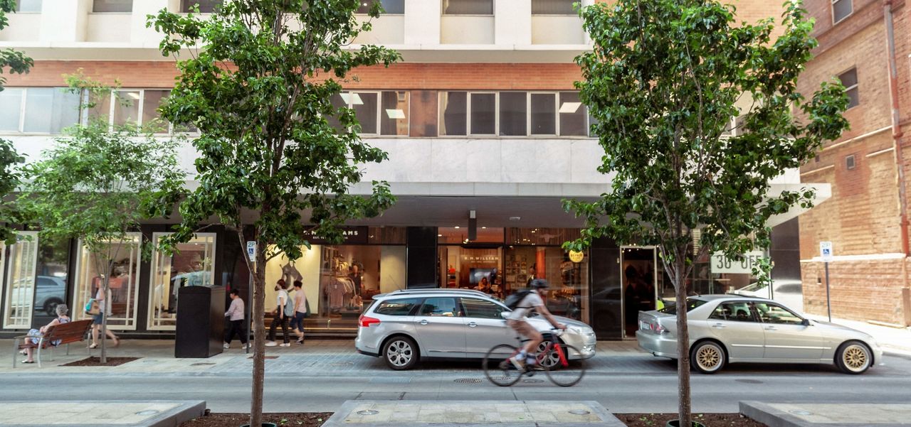 A view of the street with cars and trees visible