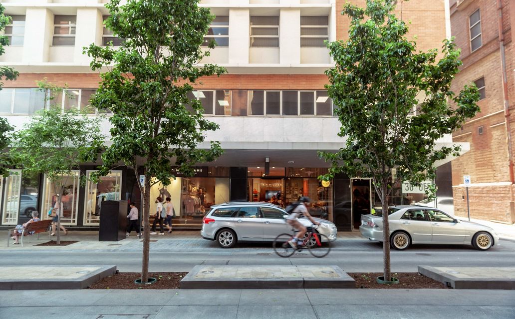 A view of the street with cars and trees visible