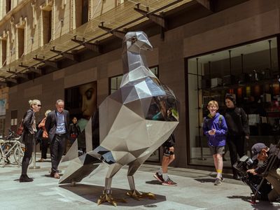 A large silver metal pigeon sculpture