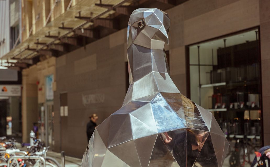 A close up of a large metal pigeon sculpture