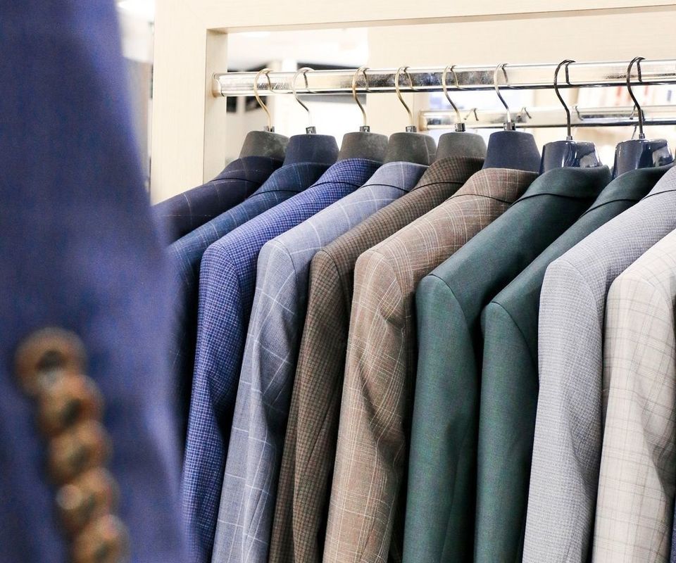 A rack of mens suits jackets in an array of colours