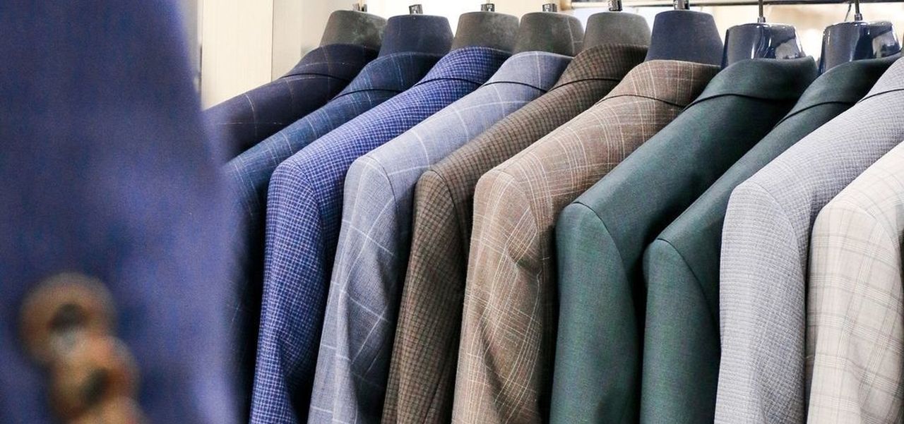 A rack of mens suits jackets in an array of colours