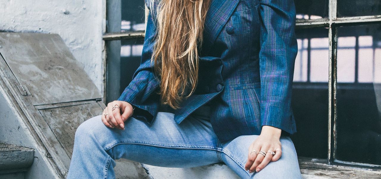 A woman wearing a denim jacket and jeans