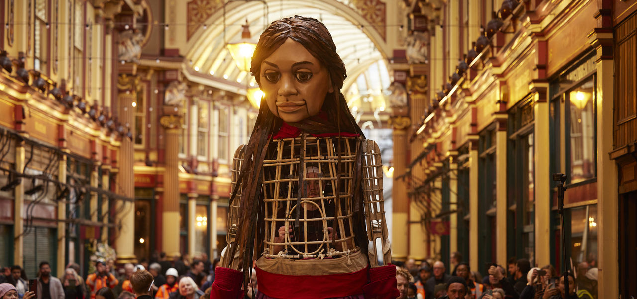 Little Amal puppet with a crowd of people