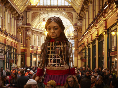 Little Amal puppet with a crowd of people