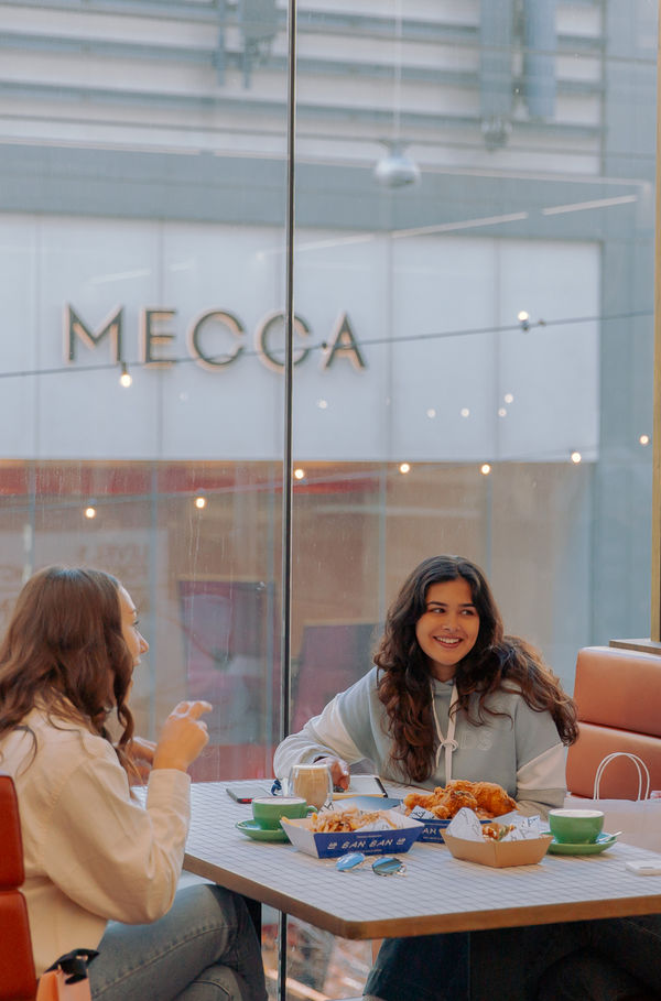Group of girls sitting in the Rundle Mall Plaza food court eating food
