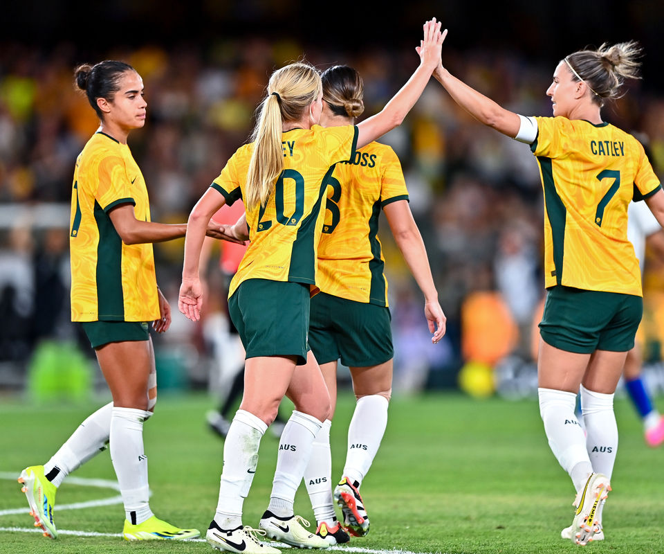 The Matilda's in a group on the soccer pitch high-fiving.