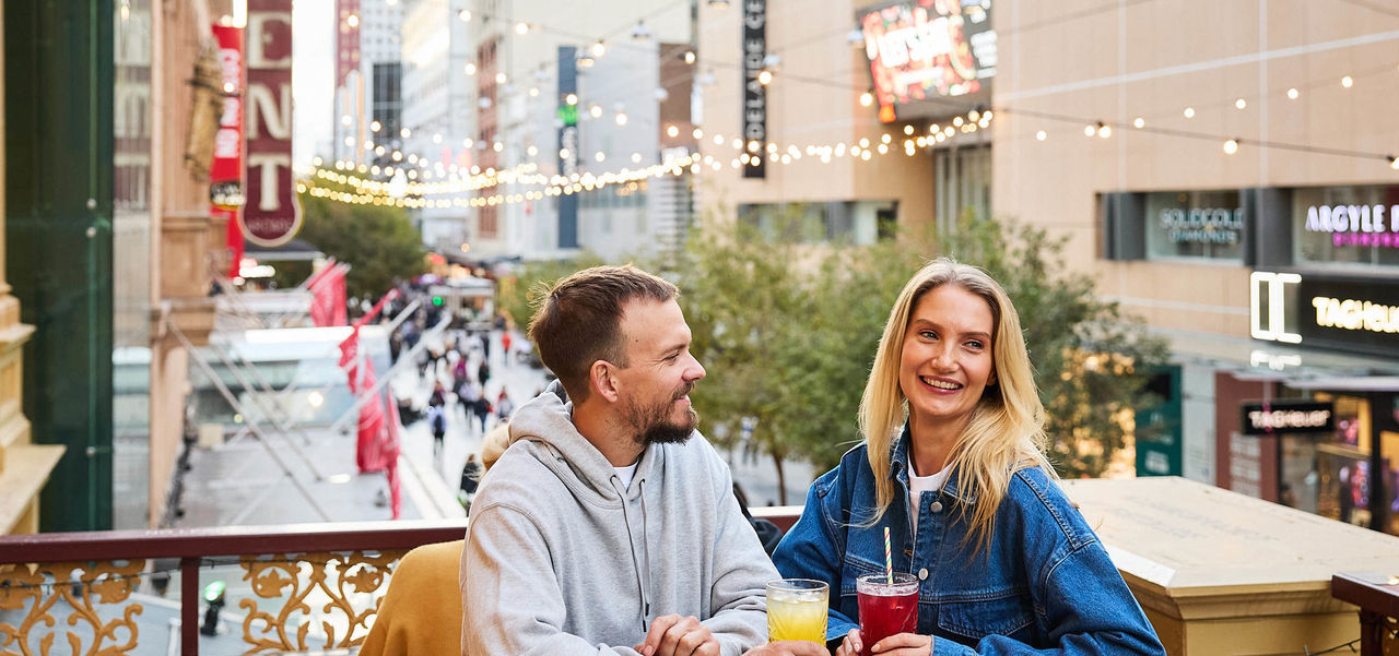 Man and woman enjoying a drink on the Two Bit Villains balcony.